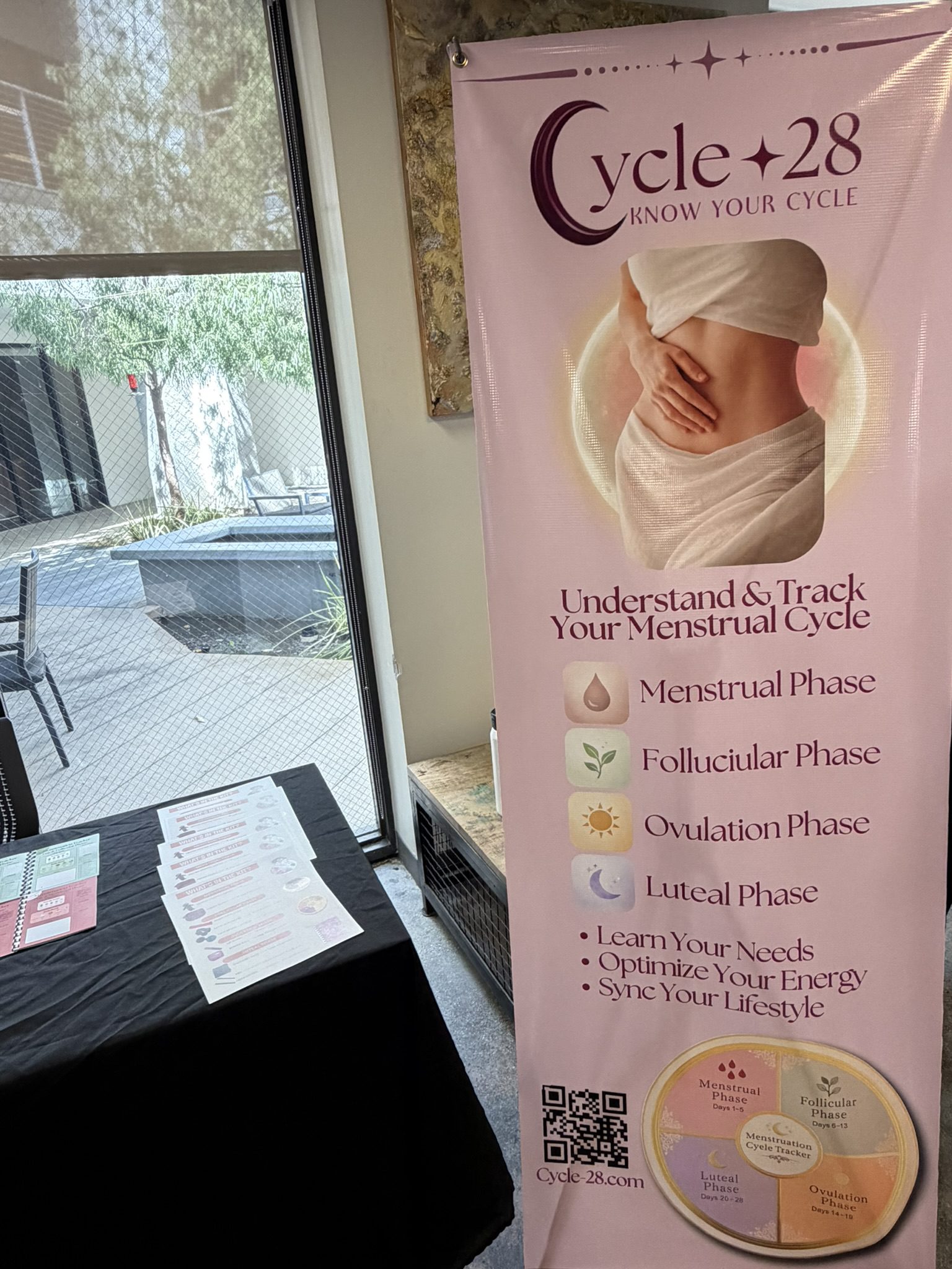 Pink banner promoting Cycle 28 with a photo of a midriff and a circle wheel showing menstrual-cycle phases; includes a QR code at the bottom left.